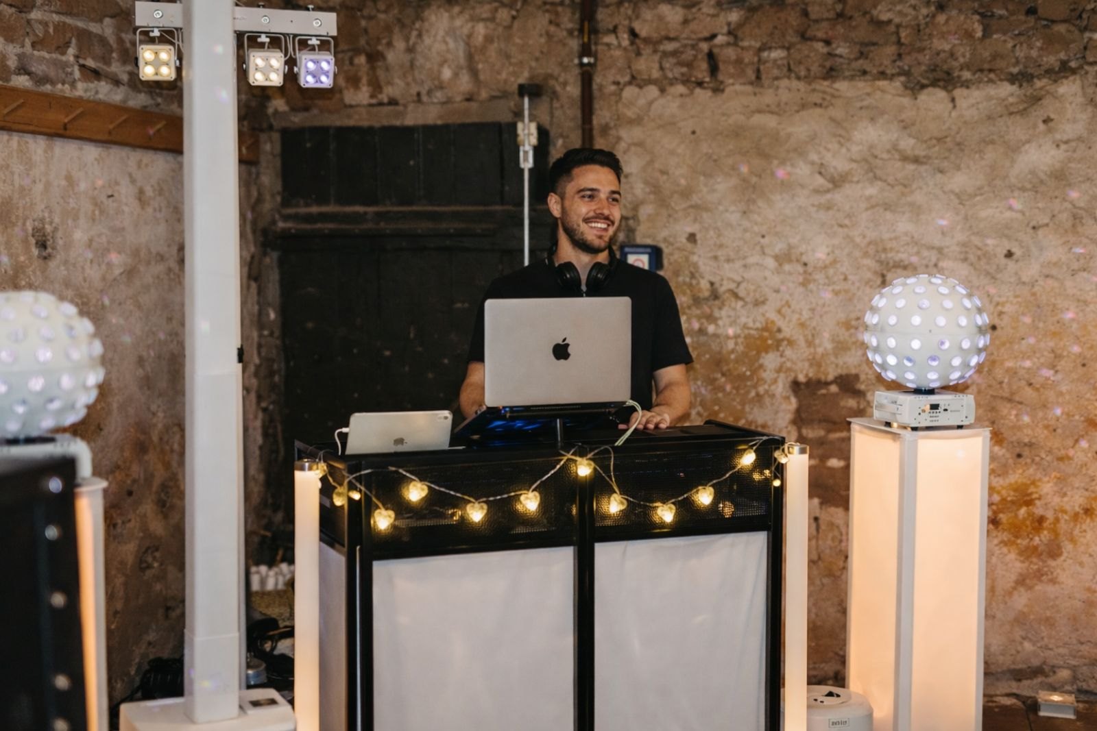 DJ von SoundMoment hinter dem Pult bei einer Feier in rustikaler Location